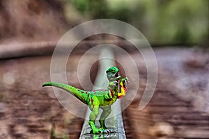 Green Velociraptor dinosaur walking on rail railroad tracks