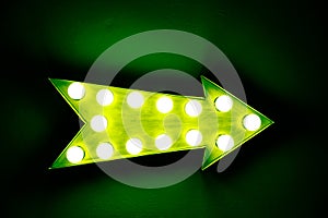 Green vintage bright and colorful illuminated display arrow sign