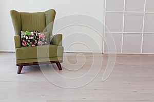 Green vintage chair with flowers in an empty white room