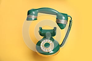Green vintage corded phone on background