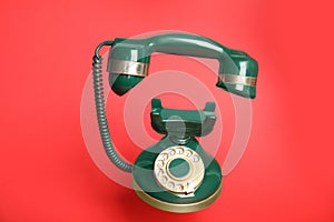 Green vintage corded phone on background