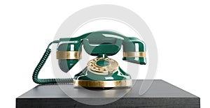 Green vintage corded phone on small black table against white background