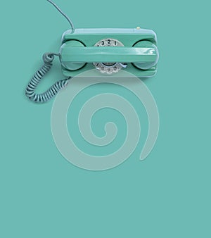 A green vintage dial telephone.