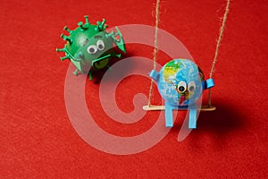 Green virus catching a toy earth on a swing
