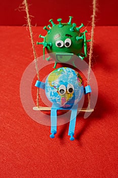 Green virus pushing a toy earth on a swing