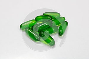 Green vitamin E softgel capsules with white background