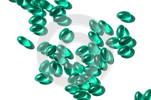 Green vitamins and pills in random order on a white background.