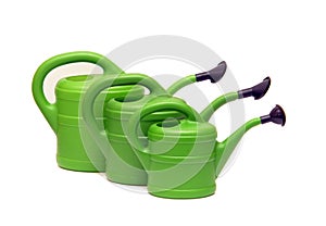 Green watering cans on white