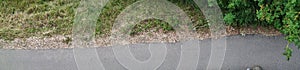 Green weed gravel and asphalt pano