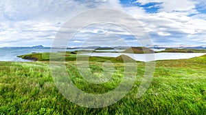 Green wetland of grassland near craters volcanics near Skutustadir. Lake Myvatn.