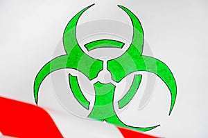 Green and white biohazard sign of biological threat alert with signal tape on the wall