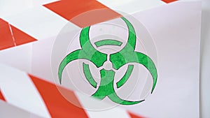 Green and white biohazard sign of biological threat alert with signal tape on the wall