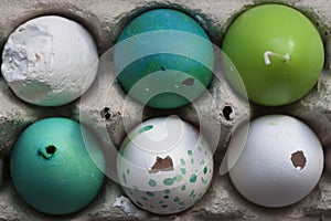 Green and white Easter eggs in egg carton. Candle egg, gypsum egg, poultry egg, ground. Close up. Rustical flat lay