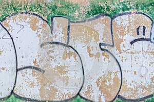 Green white graffiti on distressed wall