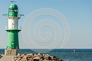 Green white lighthouse at the harbor entrance in WarnemÃ¼nde