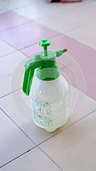 a green and white spray can sitting on a tiled floor