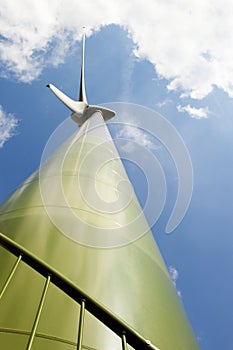 Green wind turbine taken upwards from a close-up p