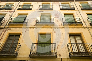 Green window shades of building in Avila Spain, an old Castilian Spanish village