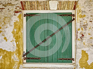 Green Window Shutters With Bar in Old Dilapidated Stone Wall