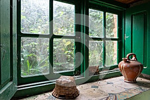 Green window sill in an abandoned house with basket and botijo photo