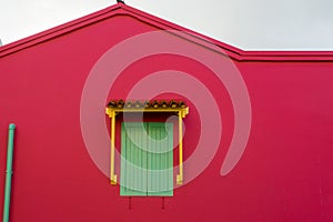 Green windows on a red wall house on the street