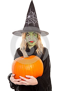 Green witch for halloween holding pumpkin