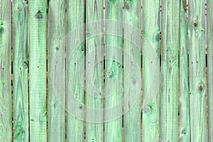 Old wooden green background of boards with cracked and paint. Fence. Wooden texture.