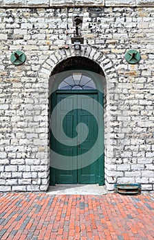 Green wooden door in white stone building