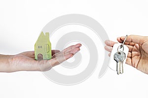 Green wooden house and key in girl hand isolate on white background