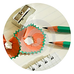 Green wooden pencils and notepad opened with pencil sharpener