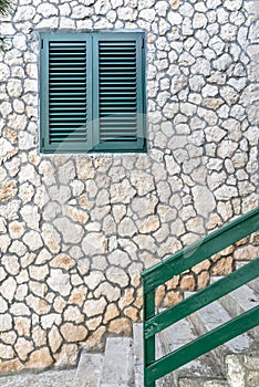 Green wooden railing, stairs and window on the sandstone wall photo