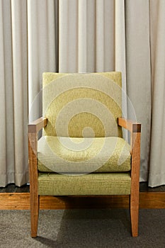 Green wooden and upholstered chair on rug. photo