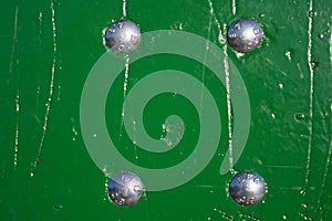 Green wooden wall texture with four bolts photo