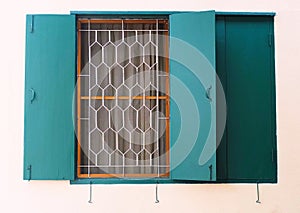 Green Wooden Window with Metal Grill on The Wall