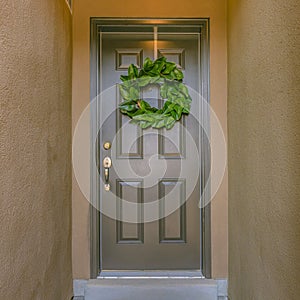 Green wreath on shiny gray front door of a home