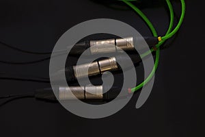 Green of XLR microphone cable on black background