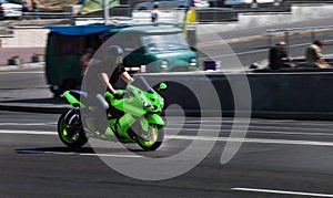 Green Yamaha sport bike Ninja travels at high speed through the city