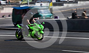 Green Yamaha sport bike Ninja travels at high speed through the city photo