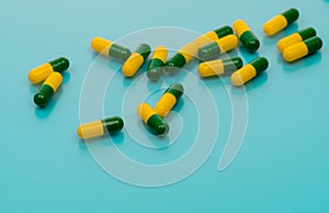 Green-yellow capsules spread on blue background. Tramadol capsule pills for relieve severe cancer pain. Painkiller medicine.