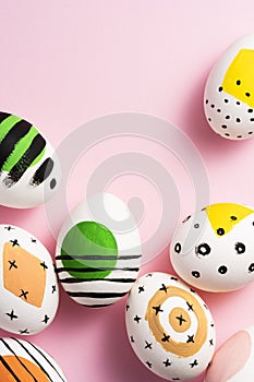 Green, yellow, orange painted easter eggs on pink background