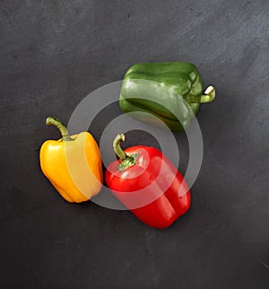 Green,yellow and red capsicum on chalkboard background