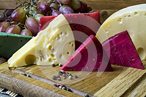 Green, yellow and red cheese lies on a cutting board