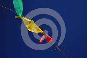 Green, yellow and red flags in blue sky, party of the street from below in brazil