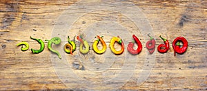 green yellow and red hot chili peppers on a old wooden background