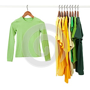 Green and yellow shirts on wooden hangers photo