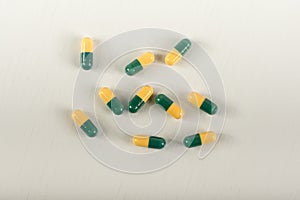 Green, yellow tramadol capsule pills on white background.Pain killer capsules called