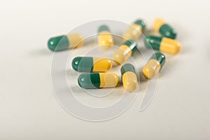 Green, yellow tramadol capsule pills on white background.Pain killer capsules called