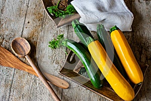 Green and yellow zucchini on wood table from above