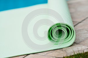 Green yoga mat near the pool