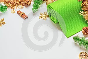 Green yoga mat or pilates mat with Christmas ornaments decoration. Christmas best gift for healthy lifestyle people concept. Yoga